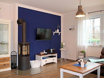 Das Wohnzimmer mit Kamin und LCD-Fernseher